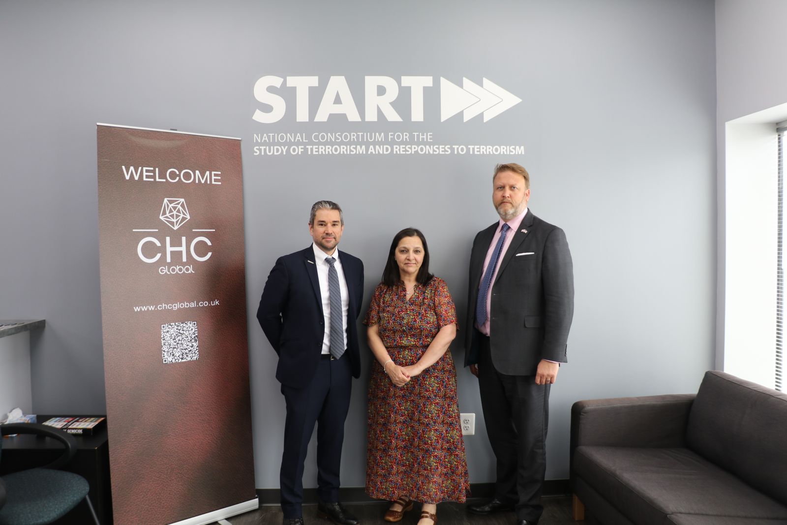 Bill Braniff, Figen Murray, and Chris Holt standing against a gray wall with the START logo in white text overhead, next to a red banner with white text reading Welcome with the CHC Global logo